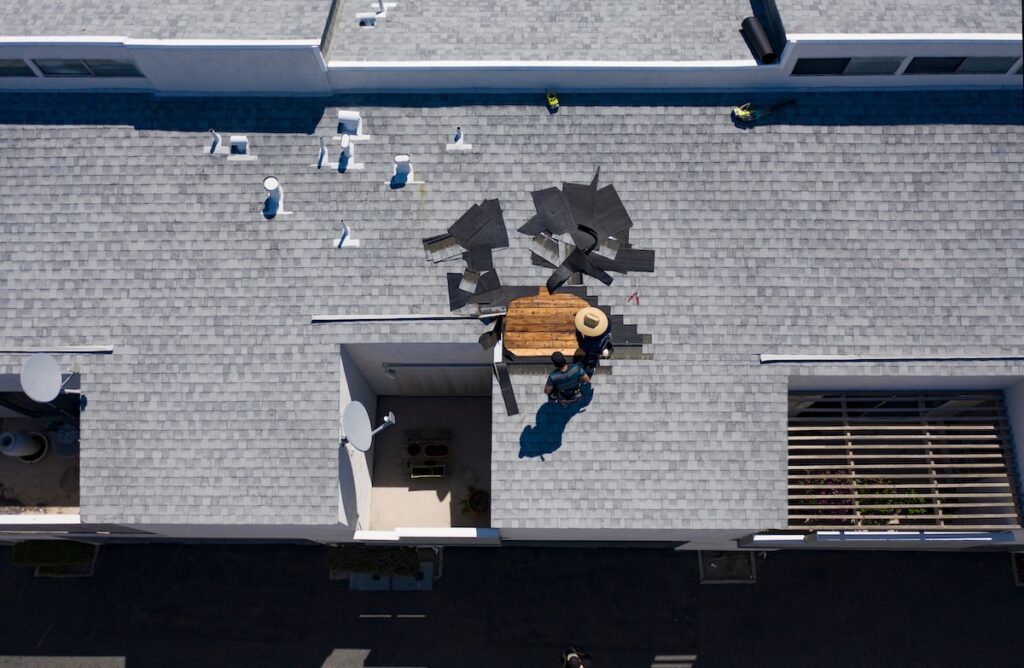 types of roof damage Roof Repair c In Progress Aerial Above Head Condo Building Gray Shingles 2 Roofers