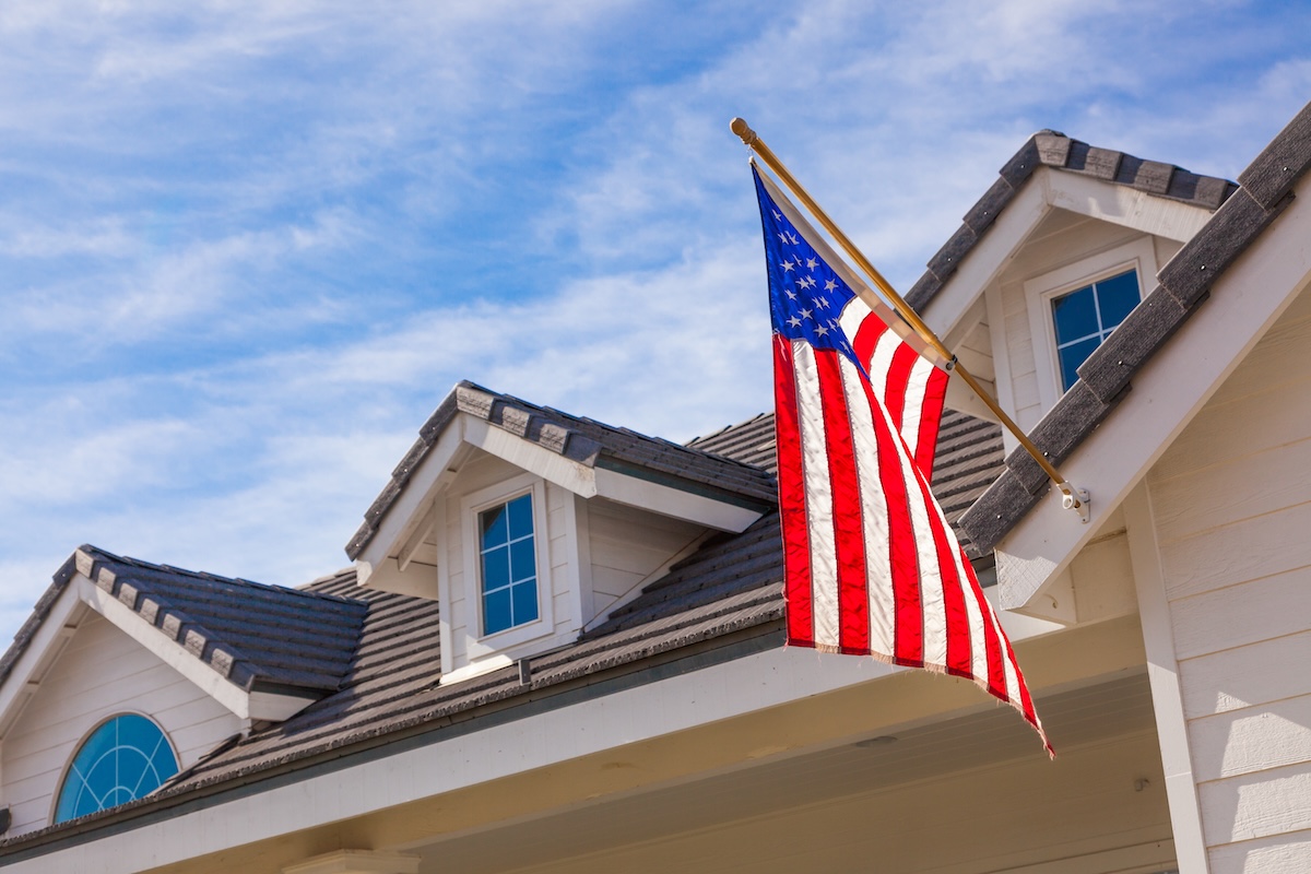 American Flag Hanging From House Facade.